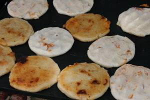 Pupusas Beef and cheese-filled pupusas fry on a griddle.