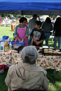 Old woman watching From a mere five feet away, the old woman quietly observes as family members fry flat corn bread.