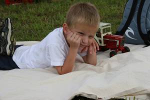This little guy charmed me immediately, when I saw him stretched out on a blanket, seemingly oblivious to all the activity around him. He was quite content with his International toy tractor. And I was content to wait patiently for just the right moment to photograph him.  This is my favorite people photo.