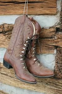 Cowboy boots hanging on the exterior of an 1860s log cabin marked the building as an on-site shoe repair shop. Inside, Randy Malecha of Willie's Shop Repair in Northfield demonstrated his craft.