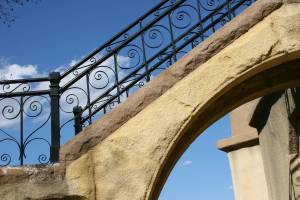 An arch and wrought iron fencing along the stairway add to the artistic beauty of the monument.