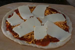 Dan prefers to use sliced, rather than shredded, mozarella cheese to top his homemade pizzas.