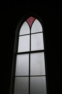 Church window The otherwise plain windows in the church are topped by points of colored glass.