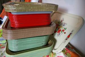 A stack of vintage trays awaits diners.
