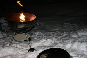 Weber grill atop a snow mound