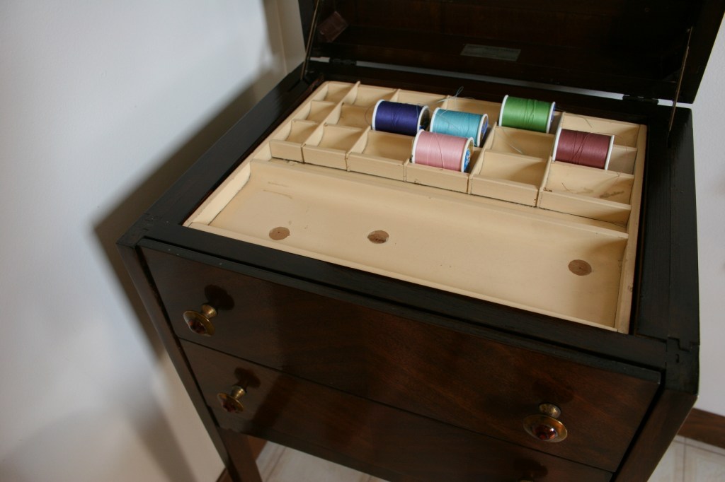 Sewing cabinet thread compartment