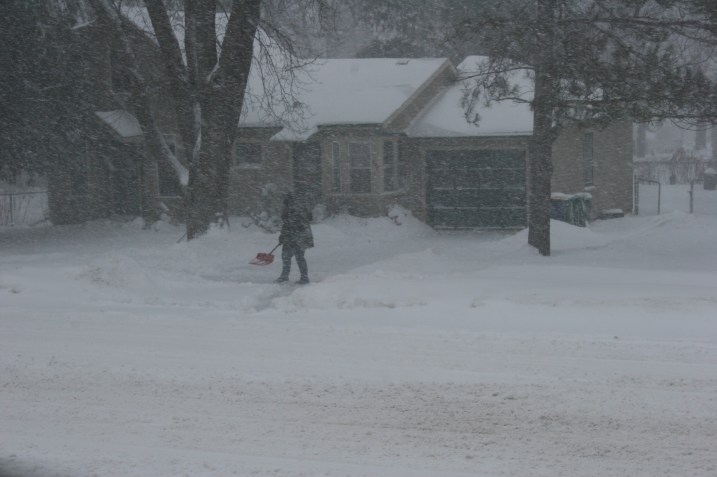 My neighbor across the street shovels snow Saturday morning.