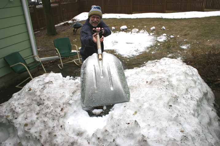 My husband shovels snow from our Minnesota backyard patio a year ago.