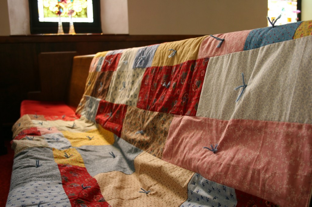 Close-up of quilts on pew