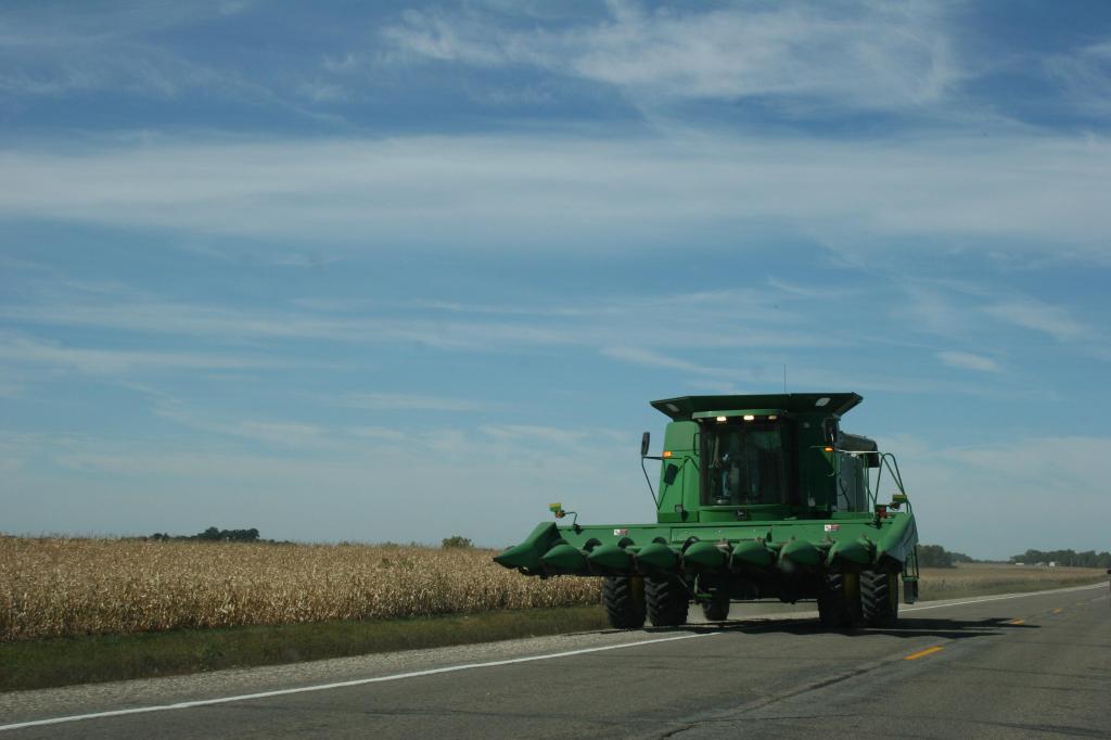 Harvest JD combine on road