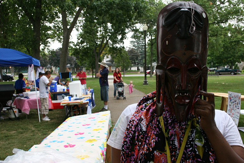 A woman, without my prompting, took this mask from the table manned by Bashir Omar and Asher Ali and asked me to photograph her.