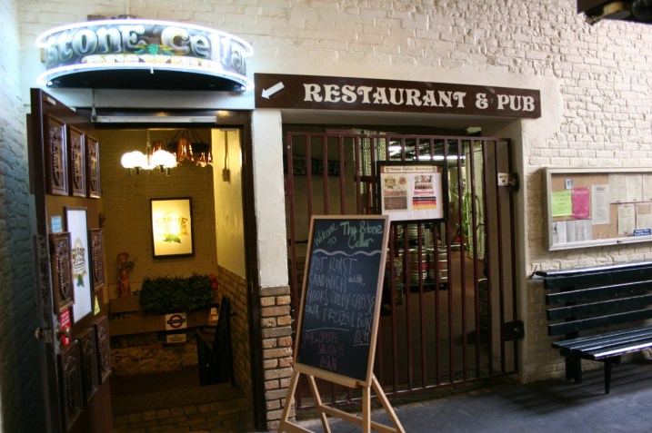 Go through the doorway on the left and follow the steps down into the Stone Cellar Brewpub.