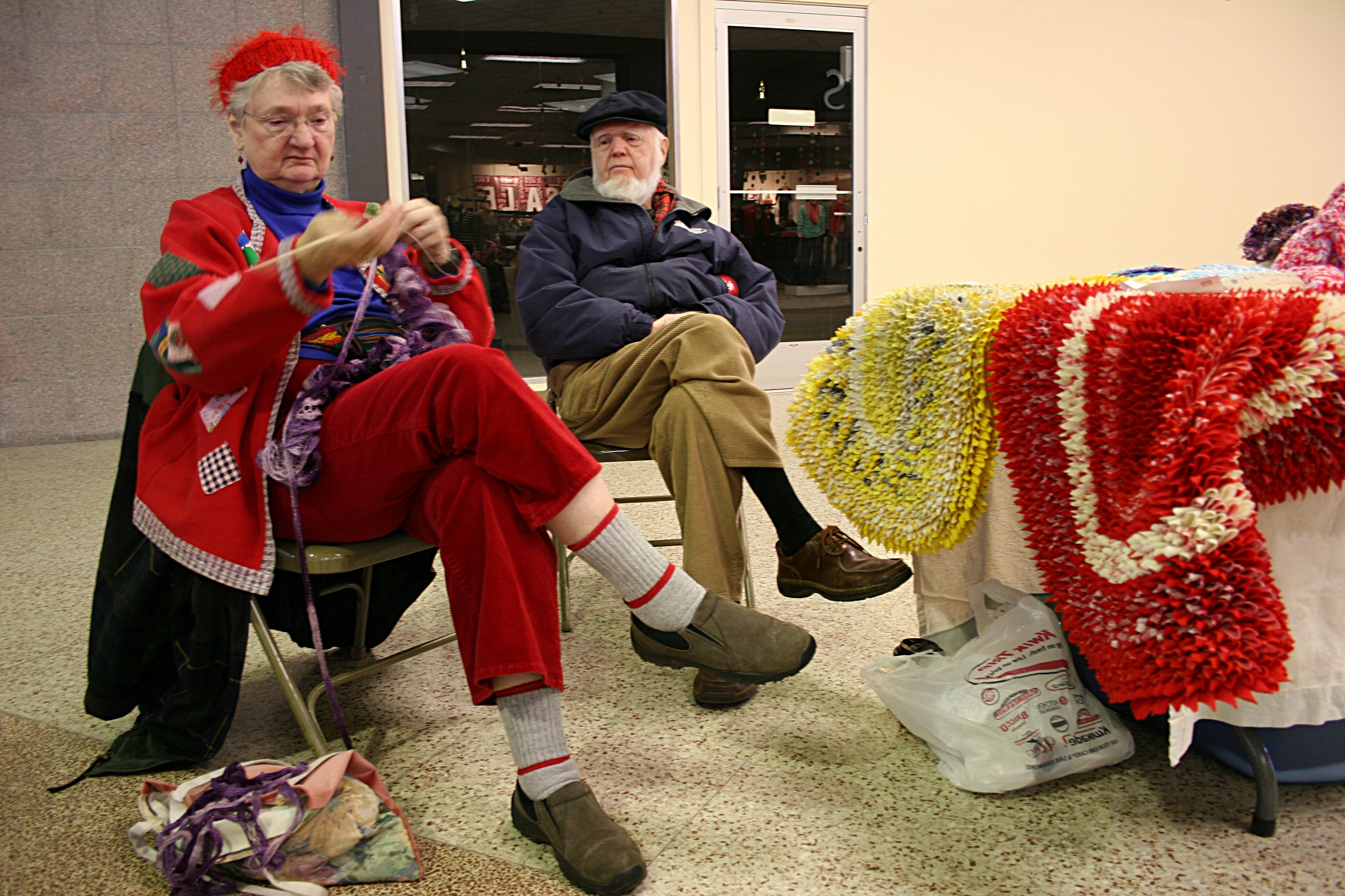 Nyla Wille knits while she and her husband tend their table.