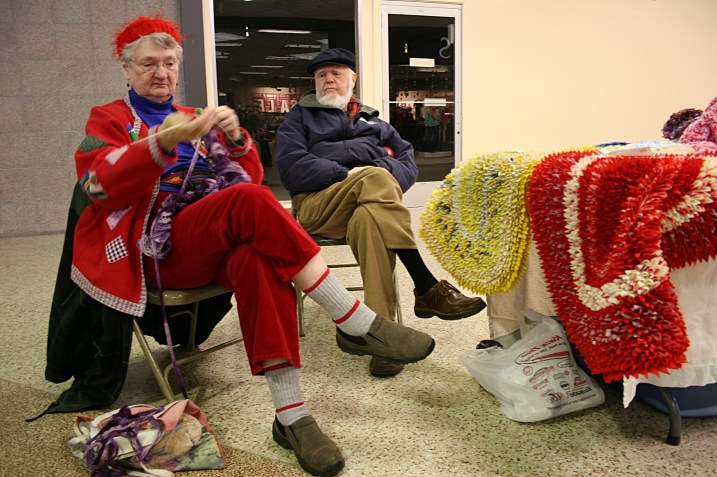 Nyla Wille knits while she and her husband tend their table.