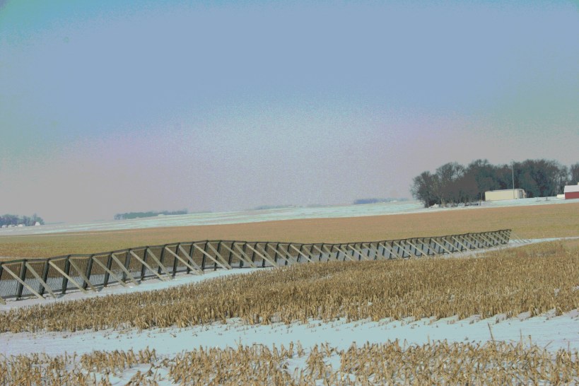 West of Springfield, a snow fence emphasizes the horizontal lines of the prairie.