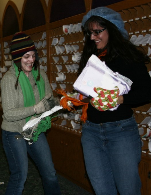 Mandy, left, and Billie Jo vie to open a gift wrapped in multiple layers of boxes and wrapping paper and secured with layers of duct and packaging tape.