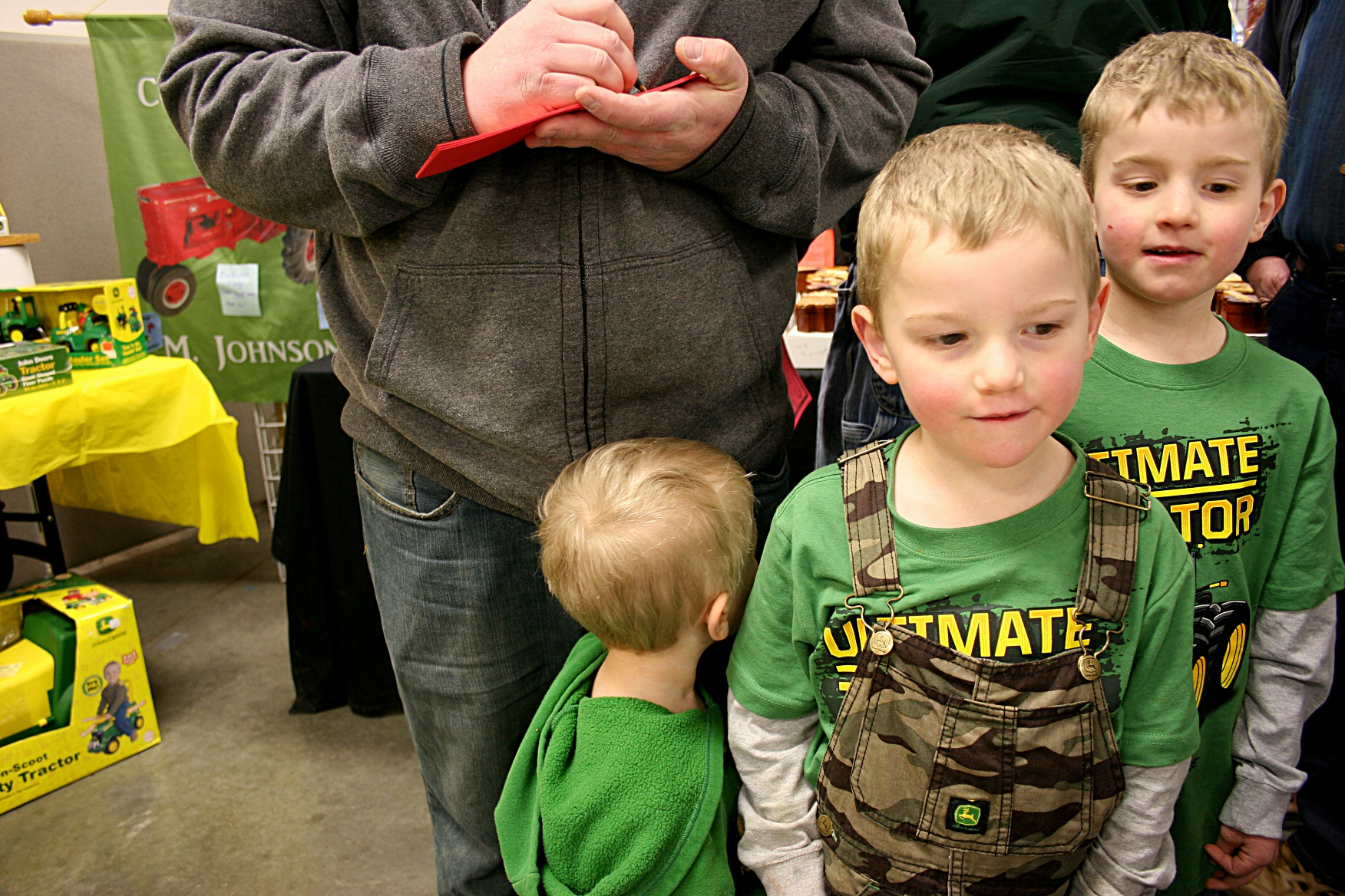 A trio of brothers dressed in John Deere attired waited while their dad signed up for a Massey Harris tractor raffle from Rice County Steam & Gas Engines, Inc.