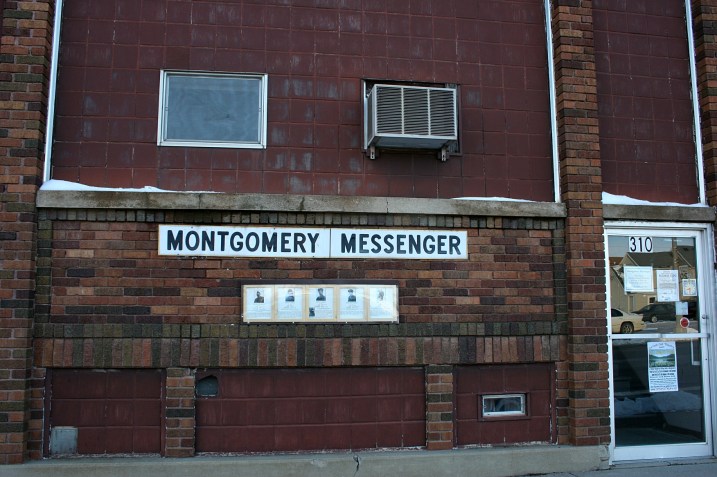 Several vets' photos hang on the exterior of the local newspaper office, The Montgomery Messenger.