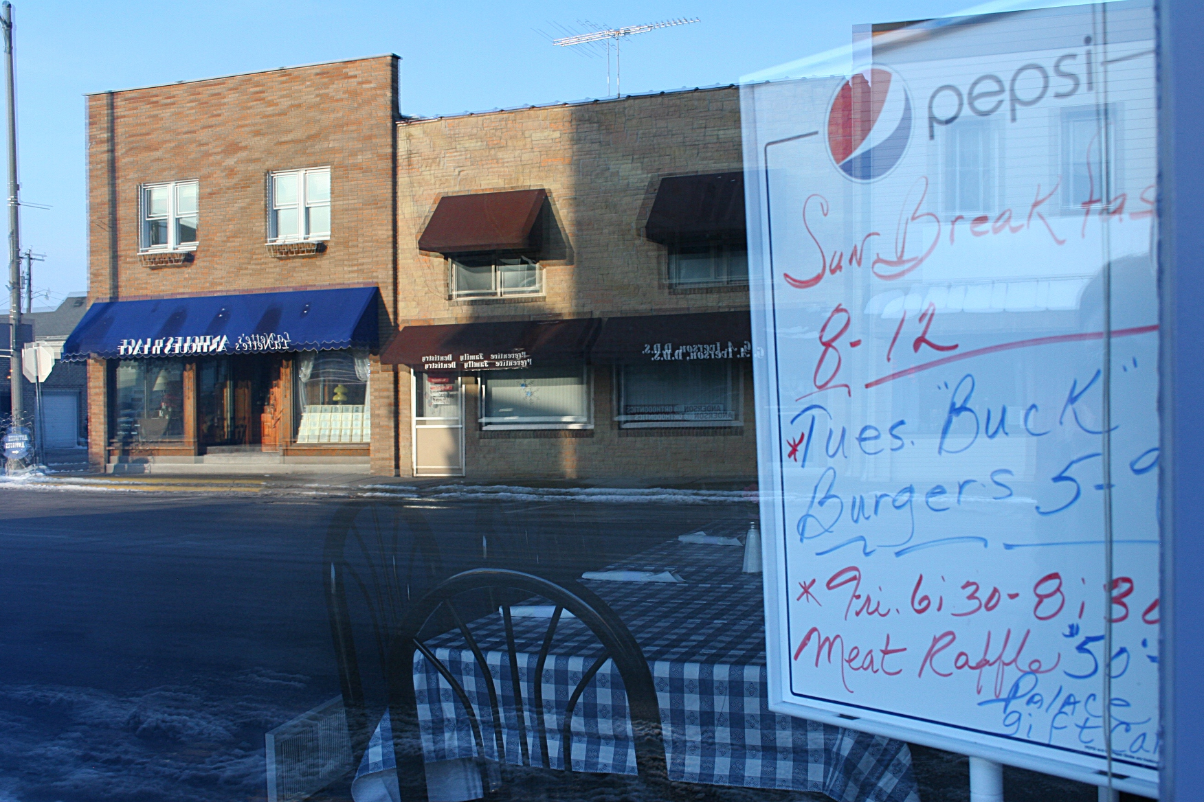 So small town: burgers and a meat raffle promoted on a whiteboard in a restaurant window.