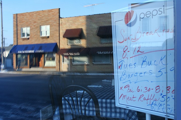So small town: burgers and a meat raffle promoted on a whiteboard in a restaurant window.