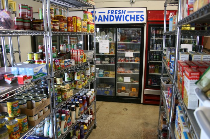 The grocery section of the store includes basic perishables like dairy products, some fruit, lettuce and more. Canned, boxed and bagged foods, personal care items, and miscellaneous items like greeting cards, tape and such fill eight shelving units.