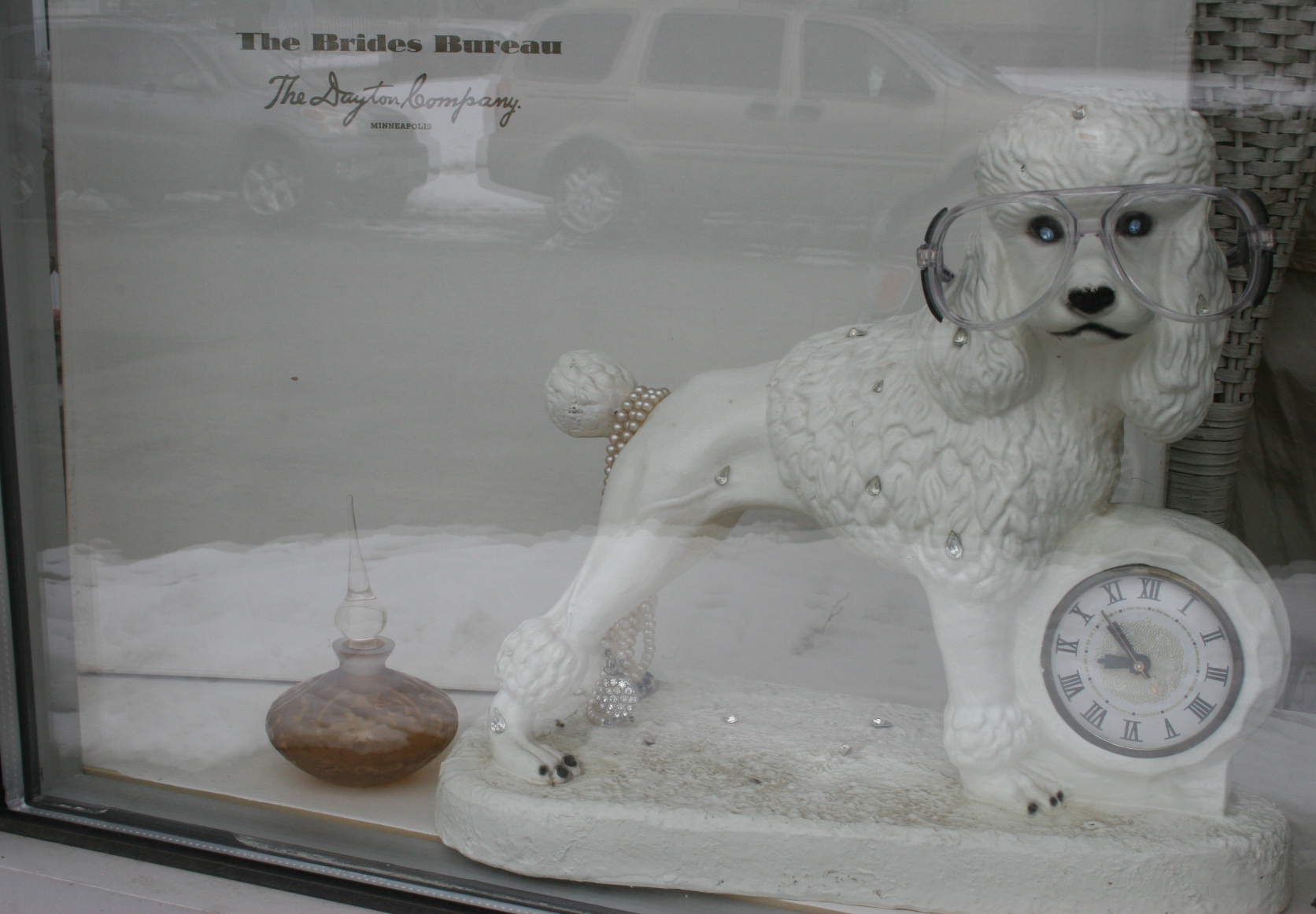 A kitschy poodle clock in a window display.