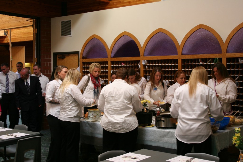 Choir members line up and dish up at the potluck after the service and concert.