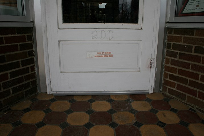 The tiled exterior entry to Franke's with a sign on the lower part of the door reading: "Kolacky Days Celebration  Czechoslovakian American Heritage.