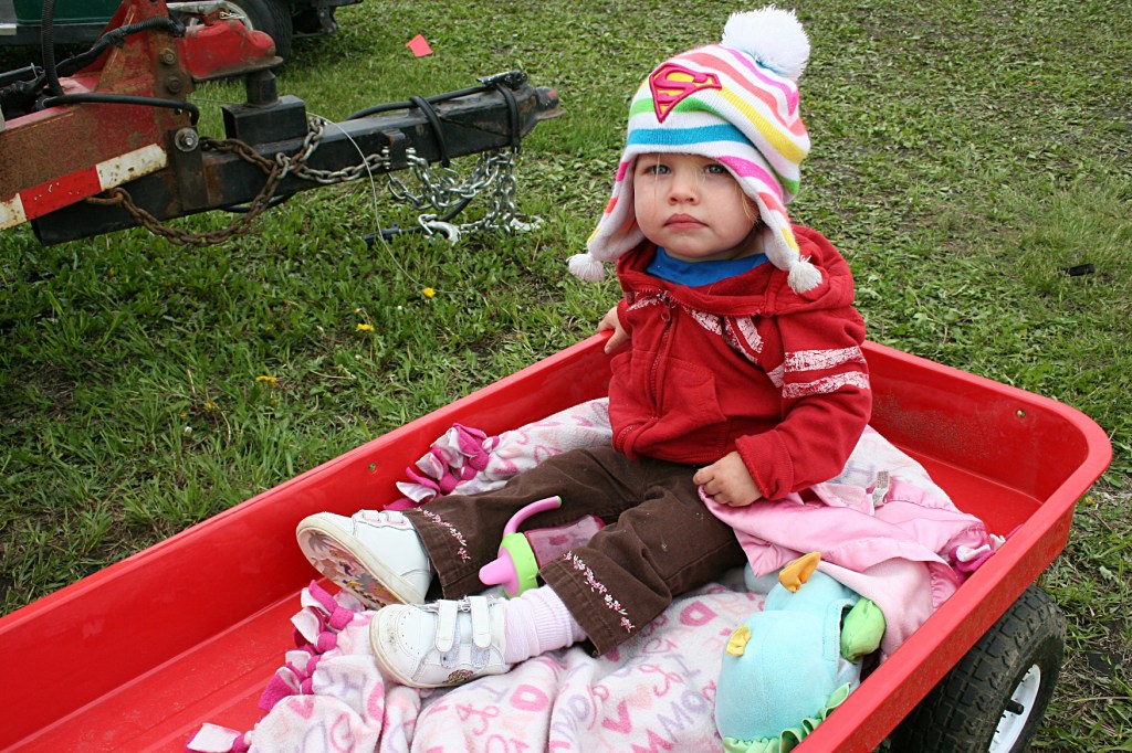Eighteen-month-old Marina, bundled up and riding in a wagon pulled by her dad.