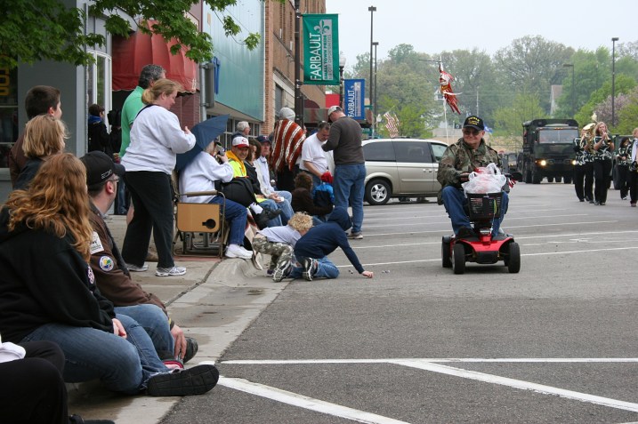 A vet on a motorized scooter tossed candy to the kids.