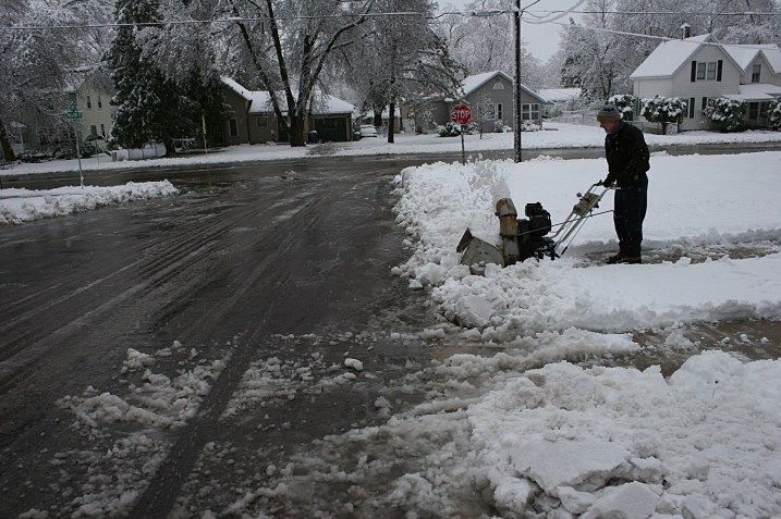 The intersection right by my house and my husband blowing snow. Note the sagging utility lines.