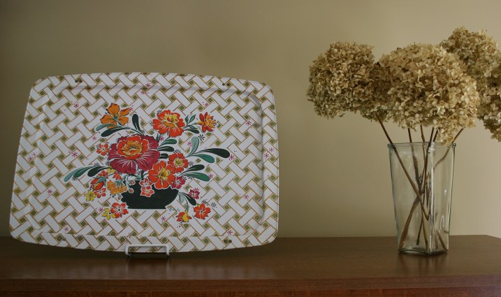 Another TV tray, repurposed as art, sits atop the entertainment center in my living room along with dried hydrangea from a bush outside my front door.