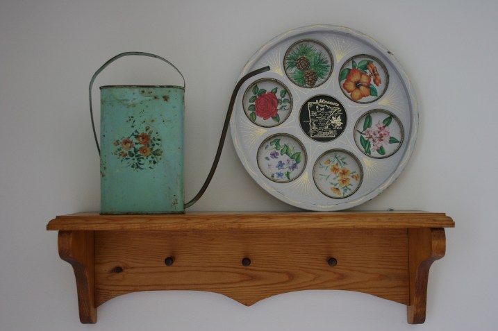 Displayed on a shelf in my dining room, this watering can was purchased at a craft store many years ago. I bought the Minnesota beverage tray at the Rice County Gas & Steam Engines Flea Market on Memorial Day weekend. I like repurposing like this tray as art.