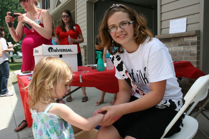 Rice County Dairy Maid Kelsey Kuball applied temporary tattoos.