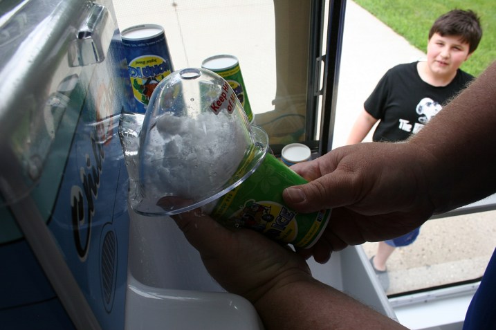 Todd guides tempered, shaved ice into a cup.