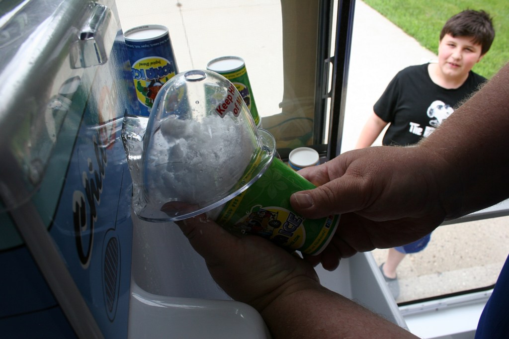 Todd guides tempered, shaved ice into a cup.