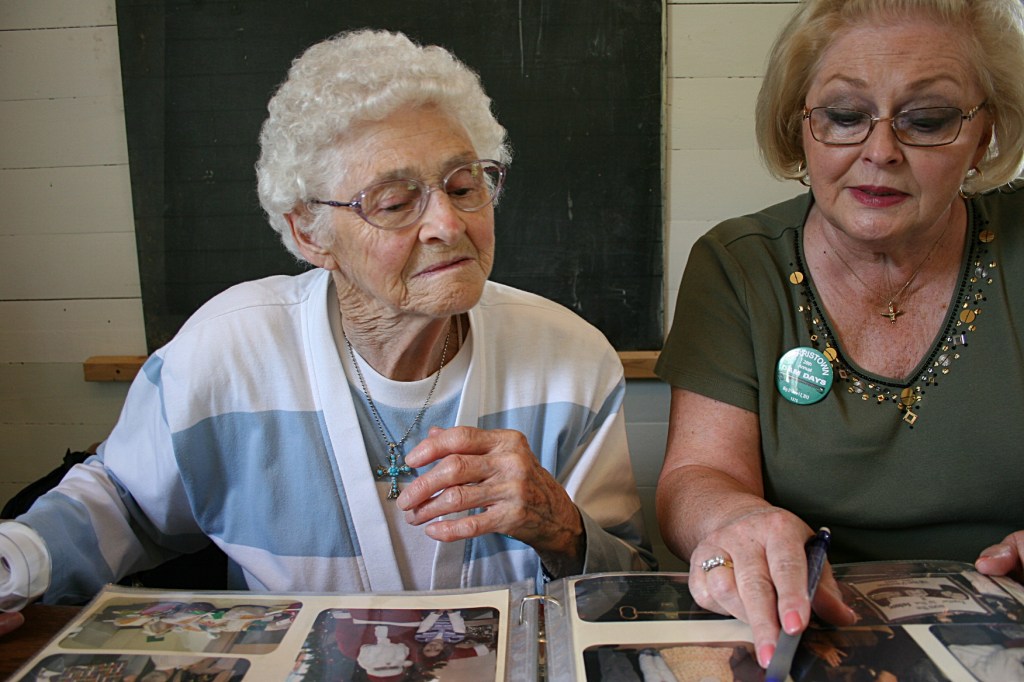 Helen and Cindy visit while they cut and tape information into the album.