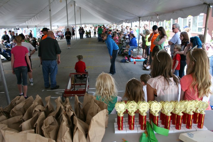 I climbed onto the back of the riser/stage to shoot this photo. In the foreground, behind the Dam Days royalty, are the trophies and ribbons and perhaps other prizes in the bags.