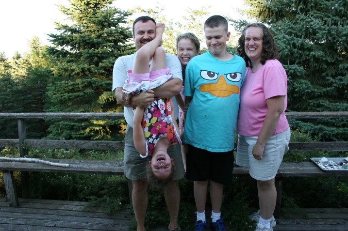 I could have chosen to show you a "perfect" family photo in which everyone in Gretchen's family is standing nice and looking at my camera. But I love this one of Ian eyeballing the antics of his little sister, Lucy. Last summer, when visiting me, Colin also held Lucy upside down for a photo and Lucy wanted to do the same again this time.