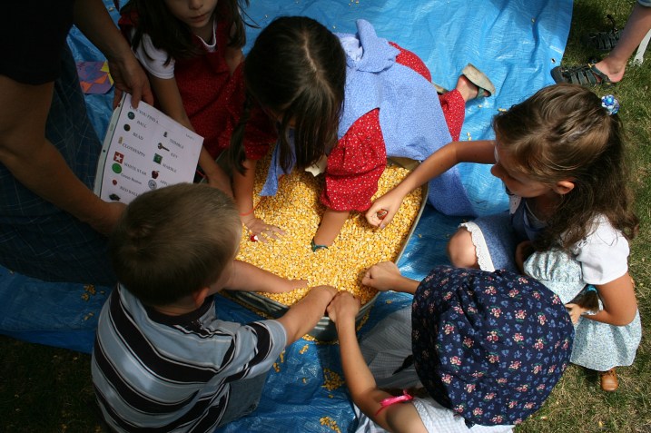Kids, including my niece, right, dig for objects in a tub of corn.
