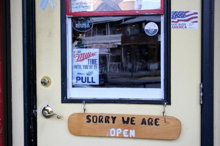 A few miles to the south in McGregor, Iowa, I found this "God bless America" sticker and humorous welcome on the door of a bar.