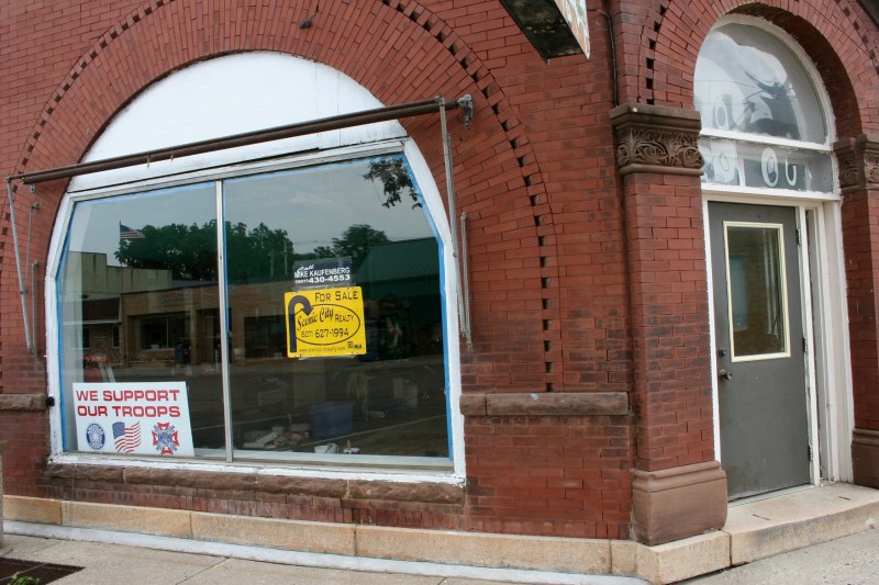 The yellow sign in the front window advertises the property for sale through Scenic City Realty.