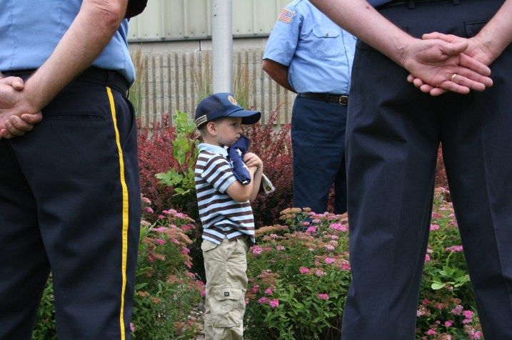 Young Carter hugs the American flag, which he accepted in honor of his military family.