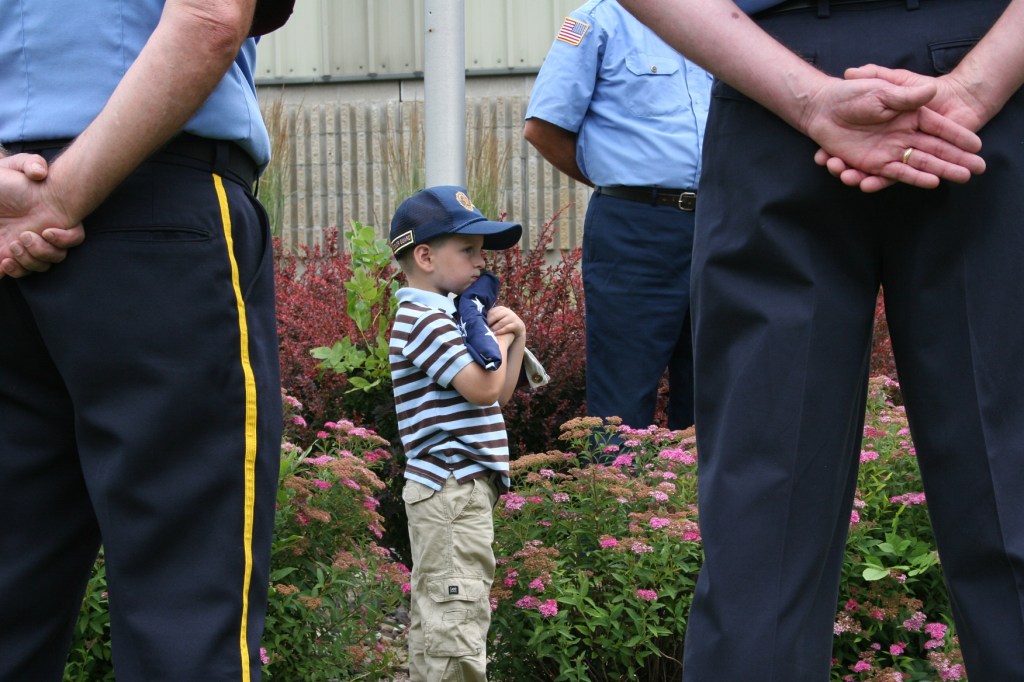 Young Carter hugs the American flag, which he accepted in honor of his military family.