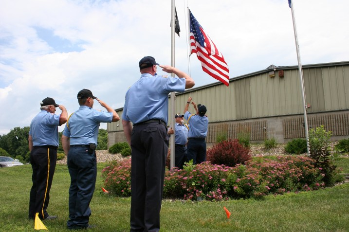 Mark Quinlan, who served with the U.S. Navy and Air Force, lowers the flag to be presented to his grandson, Carter.