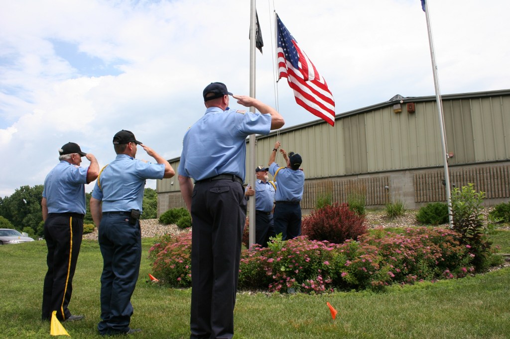 Mark Quinlan, who served with the U.S. Navy and Air Force, lowers the flag to be presented to his grandson, Carter.