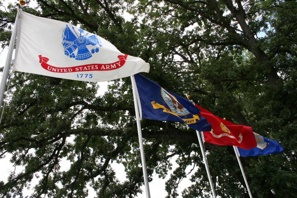 Flags from the four branches of the military fly next to Geri Larson's cabin.