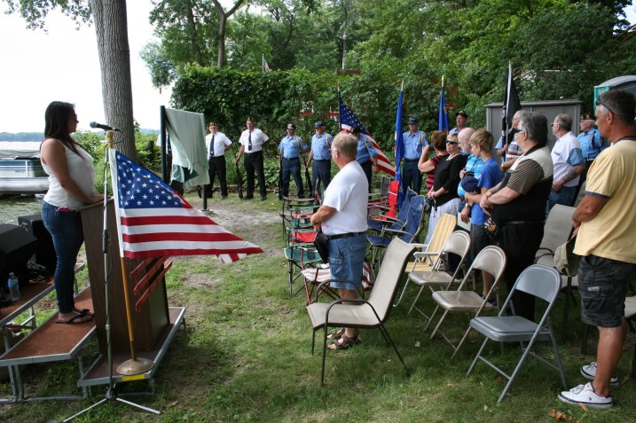 Emmee Grisim steps up to the podium to sing "The Star Spangled Banner."