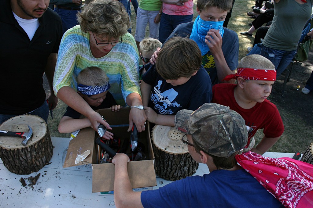 My cousin Sandy, organizer of the games, scrambles to pull boxcutters from the tool prize box before the kids grab the knives.