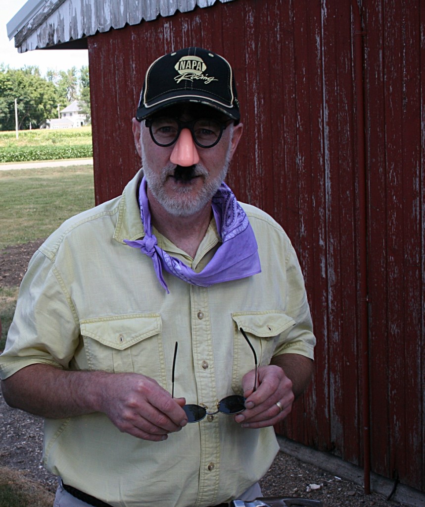 That would be my husband, Randy, sporting "safety glasses" for the nail driving contest. He wont the first round, pounding 9 1/2 nails into a chunk of wood in one minute.